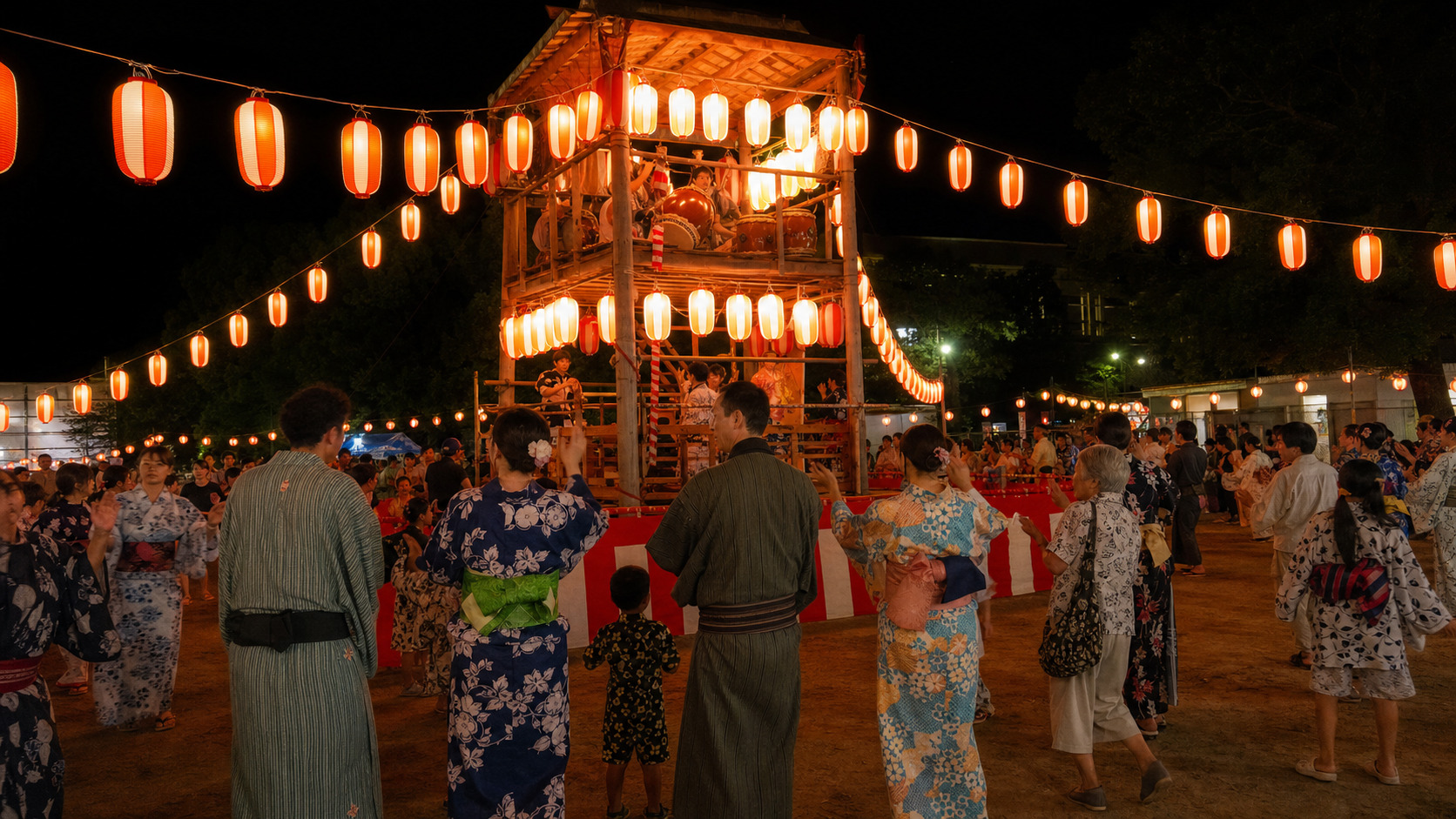 Crowd of people in yukata dancing in a circle around a wooden yagura tower at a Bon Odori festival at night