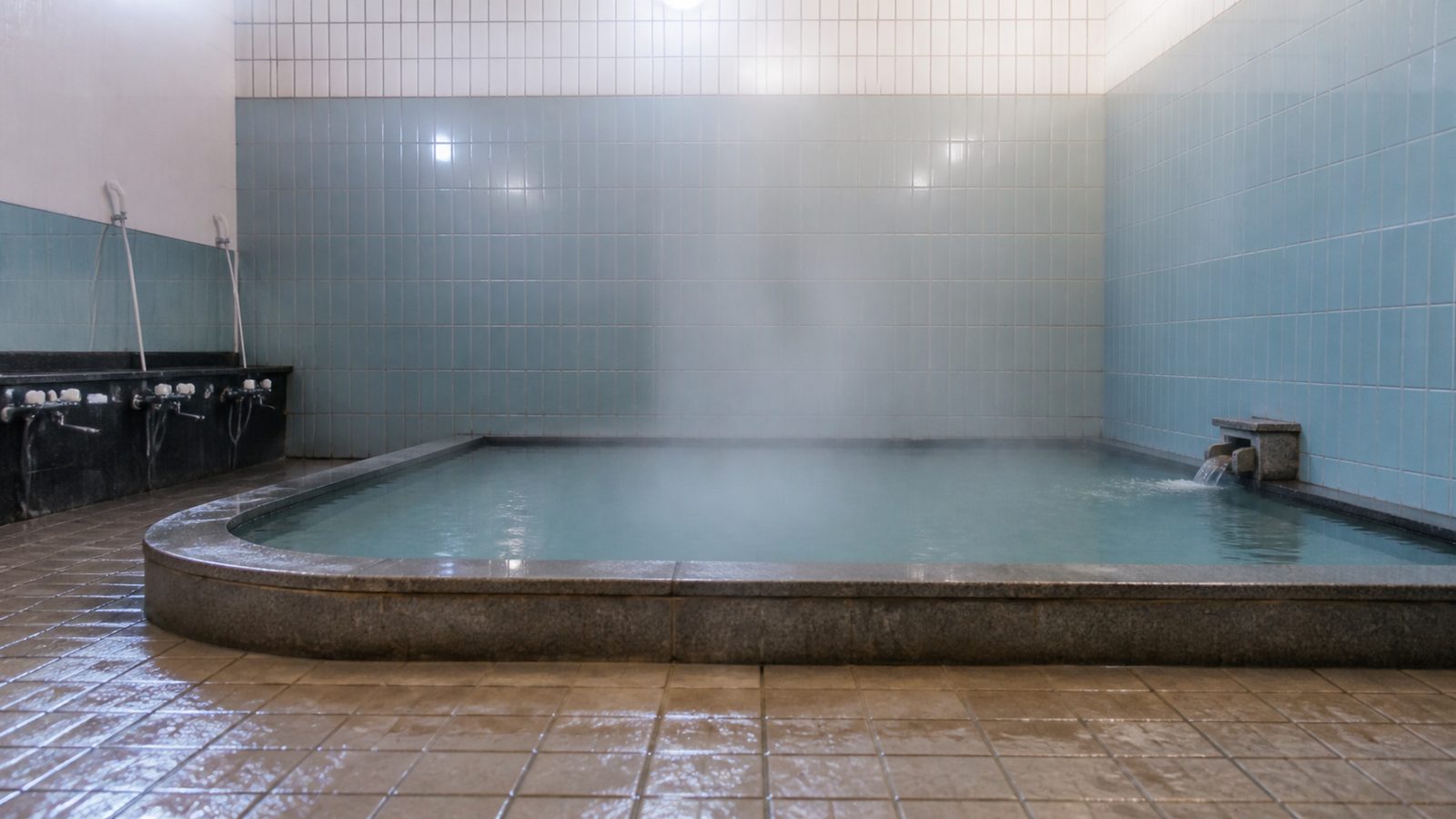 A calm blue-tiled public bath in Japan